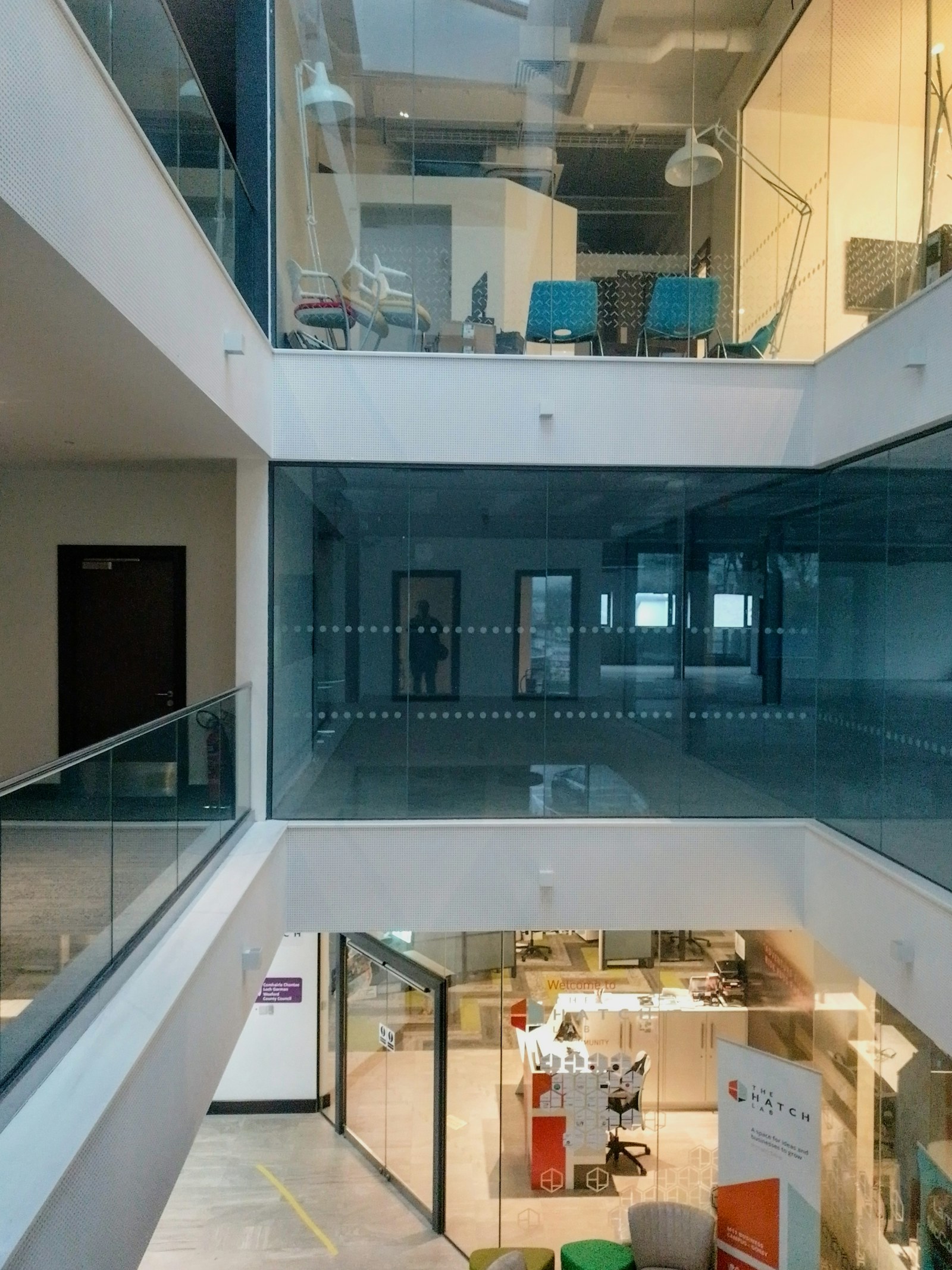 Ruang kerja modern dengan area kolaborasi dan kaca.